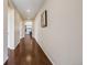 Long hallway featuring gleaming hardwood floors, leading to other rooms and a dining area at 12677 Fisher Dr, Englewood, CO 80112