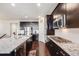 Bright, modern kitchen featuring a large island, stainless appliances, and dark wood cabinetry at 12677 Fisher Dr, Englewood, CO 80112