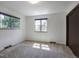 Bright bedroom featuring neutral carpet, white walls, two windows offering natural light and a door at 8893 W Harvard Dr, Lakewood, CO 80227