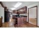View of kitchen with hardwood floors, dark wood cabinetry, and an open layout to dining area at 8893 W Harvard Dr, Lakewood, CO 80227