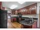 Galley kitchen features ample wood cabinets, black countertops, and modern appliances against a painted brick backsplash at 8893 W Harvard Dr, Lakewood, CO 80227