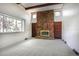 Spacious living room featuring a stone fireplace, large windows, neutral carpet, and multiple entrances at 8893 W Harvard Dr, Lakewood, CO 80227