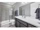 Modern bathroom featuring sleek gray tile, a glass-enclosed shower, and a dark vanity at 6066 Leilani Dr, Castle Rock, CO 80108