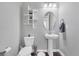Powder room features a pedestal sink, wood floors, and decorative shelving at 6066 Leilani Dr, Castle Rock, CO 80108