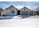 Charming single-story home with stone accents, a three-car garage, and snowy landscaping at 6066 Leilani Dr, Castle Rock, CO 80108
