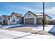 Single-story home featuring stone accents, a three-car garage, and snowy landscaping at 6066 Leilani Dr, Castle Rock, CO 80108