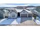 Beautiful single-Gathering home with a three-car garage, stone accents, and a snow-dusted roof against a scenic mountain backdrop at 6066 Leilani Dr, Castle Rock, CO 80108