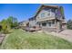 Spacious backyard with a grassy lawn, a wooden deck, and beautiful landscaping at 26764 E Canyon Ave, Aurora, CO 80016