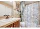 Bathroom with a single sink vanity, tiled countertop, and a shower with a patterned curtain at 26764 E Canyon Ave, Aurora, CO 80016