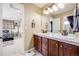 Bright bathroom featuring a double sink vanity with wood cabinets and neutral tile countertops at 26764 E Canyon Ave, Aurora, CO 80016