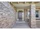 Inviting stone-clad front entrance with a stylish front door and covered porch area at 26764 E Canyon Ave, Aurora, CO 80016