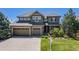 Charming two-story home featuring a three-car garage, stone accents, and a well-manicured front yard at 26764 E Canyon Ave, Aurora, CO 80016