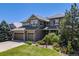 Beautiful two-story home with three-car garage, stone accents, and lush landscaping at 26764 E Canyon Ave, Aurora, CO 80016
