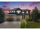 Stunning two-story home featuring a three-car garage, stone accents, and beautifully landscaped front yard against a gorgeous sky at 26764 E Canyon Ave, Aurora, CO 80016