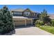 Lovely two-story home with a three-car garage, stone accents, and mature trees in the front yard at 26764 E Canyon Ave, Aurora, CO 80016