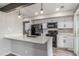 Well-lit kitchen with black appliances, white cabinetry, and a convenient peninsula island at 4899 S Dudley St # 14F, Littleton, CO 80123