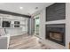 Open-concept living room with fireplace, modern decor, and sliding glass door to balcony at 4899 S Dudley St # 14F, Littleton, CO 80123