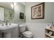 Classic half-bath with pedestal sink, wainscoting, and decorative wall art at 4094 S Lisbon Way, Aurora, CO 80013