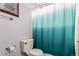 Bathroom featuring a toilet with a turquoise ombre shower curtain hanging on the shower rod at 4094 S Lisbon Way, Aurora, CO 80013