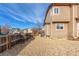 Side yard showing tan siding, light stone landscaping, and a wooden fence, offering privacy and curb appeal at 4094 S Lisbon Way, Aurora, CO 80013