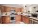 Functional kitchen boasts modern appliances, wood cabinetry, and bright, white countertops at 4094 S Lisbon Way, Aurora, CO 80013