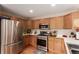 Well-lit kitchen showcases stainless steel appliances, ample counter space, and wood-finish cabinets at 4094 S Lisbon Way, Aurora, CO 80013