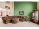 Inviting living room featuring a large sectional sofa, green accent wall, and vaulted ceilings at 4094 S Lisbon Way, Aurora, CO 80013