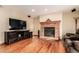 Cozy living room featuring a brick fireplace, hardwood floors, and comfortable seating at 4094 S Lisbon Way, Aurora, CO 80013