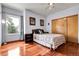 Cozy bedroom featuring hardwood floors, large window, a ceiling fan, and a closet at 11411 W Cooper Dr, Littleton, CO 80127
