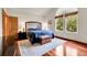 Comfortable bedroom offers wood floors and a large window providing natural light at 11411 W Cooper Dr, Littleton, CO 80127