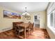 Inviting dining room features a wood table, chandelier, and a serene mountain landscape art piece at 11411 W Cooper Dr, Littleton, CO 80127