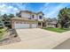 A charming two-story home features a brick and siding exterior, well-maintained lawn, and a three-car garage at 11411 W Cooper Dr, Littleton, CO 80127