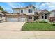 A charming two-story home features a brick and siding exterior, well-maintained lawn, and a three-car garage at 11411 W Cooper Dr, Littleton, CO 80127