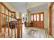Inviting foyer showcasing a beautiful wood front door, tile flooring, and staircase leading to upper level at 11411 W Cooper Dr, Littleton, CO 80127