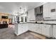 Open-concept kitchen with granite counters, white cabinets, and seamless flow to the living area at 11411 W Cooper Dr, Littleton, CO 80127