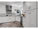 Well-lit modern kitchen boasts white cabinetry, stainless steel appliances, and stylish backsplash at 11411 W Cooper Dr, Littleton, CO 80127