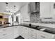 This contemporary kitchen features granite countertops, modern appliances, and a unique backsplash design at 11411 W Cooper Dr, Littleton, CO 80127