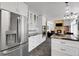 Spacious kitchen with stainless steel fridge, modern appliances, and seamless flow to the living area at 11411 W Cooper Dr, Littleton, CO 80127