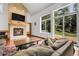 Comfortable living room featuring a brick fireplace, high ceilings, and large windows with backyard views at 11411 W Cooper Dr, Littleton, CO 80127
