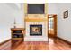 Living room featuring a brick fireplace, a TV, and hardwood flooring at 11411 W Cooper Dr, Littleton, CO 80127