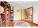 Bright office space with a large bookshelf, hardwood floors, and a doorway that leads back to the entrance at 11411 W Cooper Dr, Littleton, CO 80127