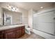 Bathroom showcasing a vanity with neutral countertops and a shower/tub combo with glass doors at 4415 Echo Ct, Larkspur, CO 80118
