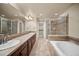 Bright bathroom featuring double sinks, a soaking tub, and a separate shower at 4415 Echo Ct, Larkspur, CO 80118