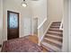 Inviting foyer featuring a decorative glass front door, hardwood floors, a staircase, and neutral wall paint at 4415 Echo Ct, Larkspur, CO 80118