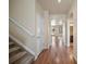 Hallway view featuring carpeted stairs, wood floors, arched doorways, and neutral paint at 4415 Echo Ct, Larkspur, CO 80118