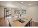 Bright, airy kitchen featuring an island with a sink, granite countertops, and views of an outdoor patio at 4415 Echo Ct, Larkspur, CO 80118