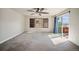 Spacious living area featuring neutral walls, tan carpet, a sliding glass door, and a shuttered window at 4415 Echo Ct, Larkspur, CO 80118