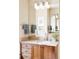 Well-lit bathroom vanity with wood cabinets, a mirror, and decorative lighting, creating a warm ambiance at 7080 W Custer Ave, Lakewood, CO 80226