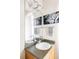 Bright bathroom features an undermount sink, unique vanity lighting and neutral wall art at 7080 W Custer Ave, Lakewood, CO 80226