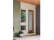 Inviting entryway featuring a modern wood door with glass pane, a window, and a brick wall at 7080 W Custer Ave, Lakewood, CO 80226